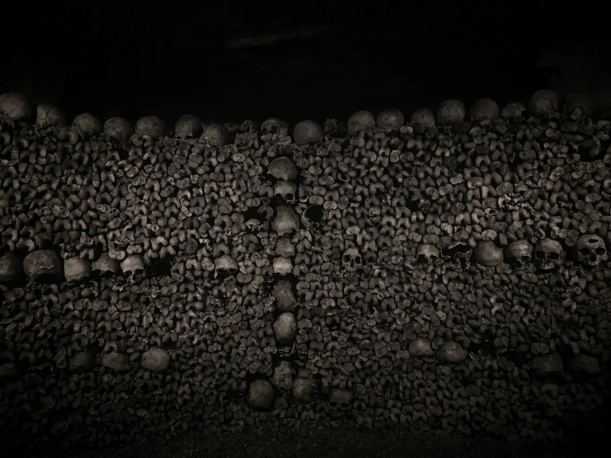 Ossements et crânes dans l'obscurité des galeries des Catacombes de Paris