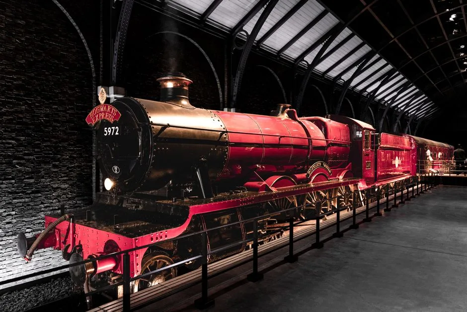 Locomotive Hogwarts Express exposée dans un hall sombre