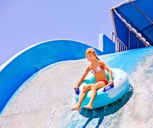 Jeune fille sur une bouée dans un toboggan aquatique de Plopsaqua De Panne