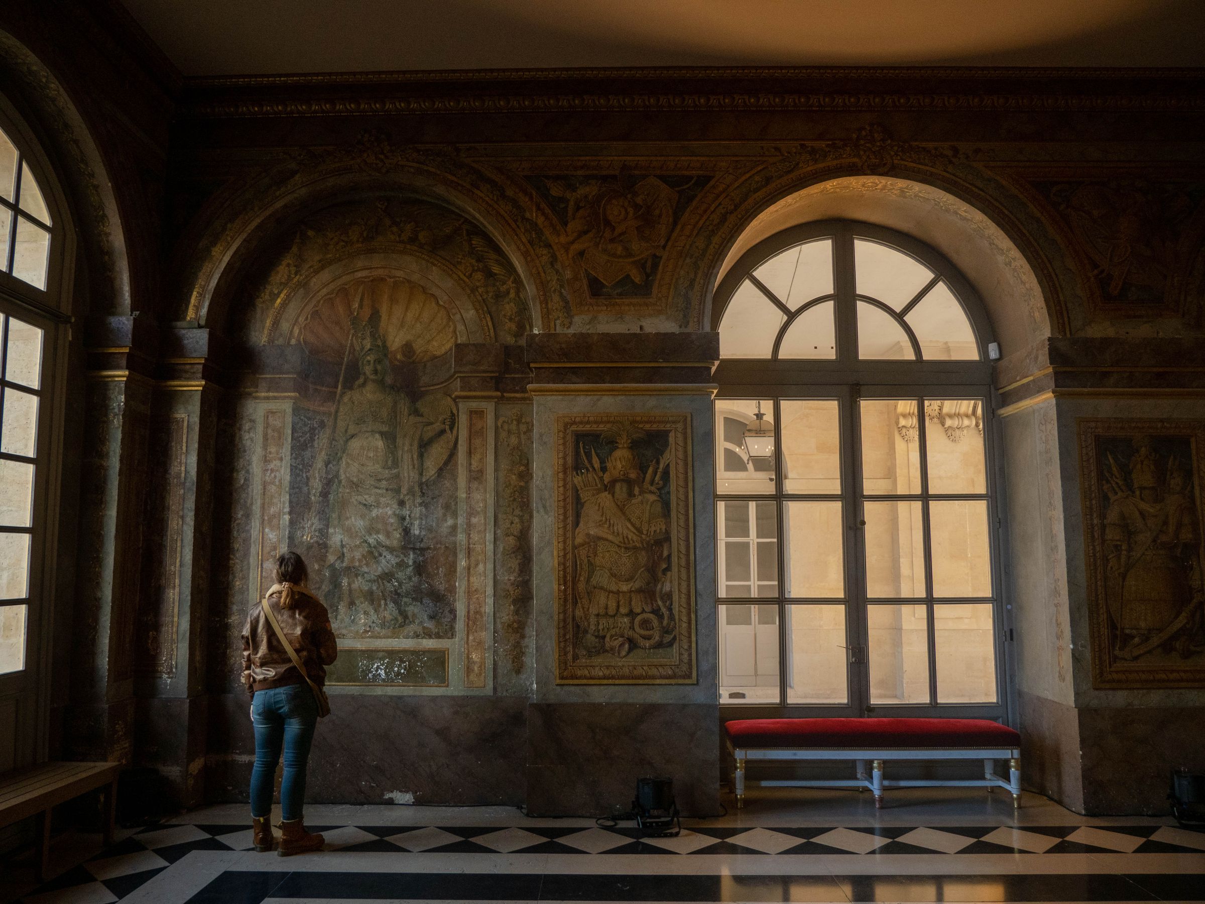 Visiteuse devant des fresques dans un intérieur du Château de Versailles