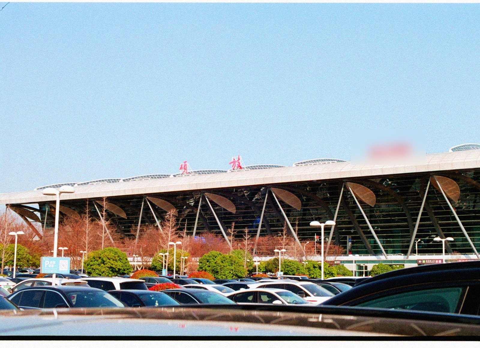 Parking d'aéroport avec des voitures devant un terminal