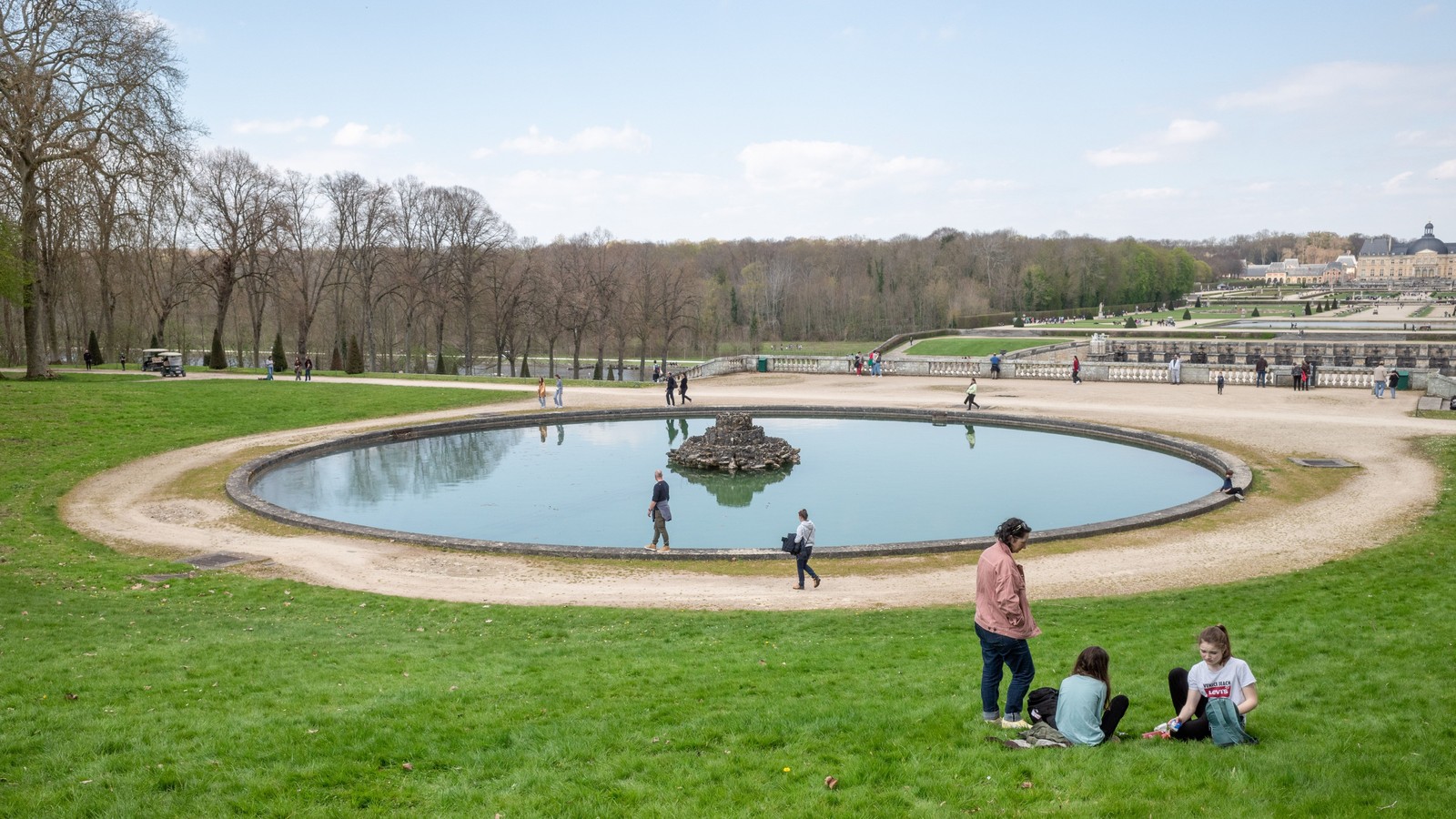 Promeneurs et visiteurs longeant le grand bassin dans les jardins de Vaux-le-Vicomte