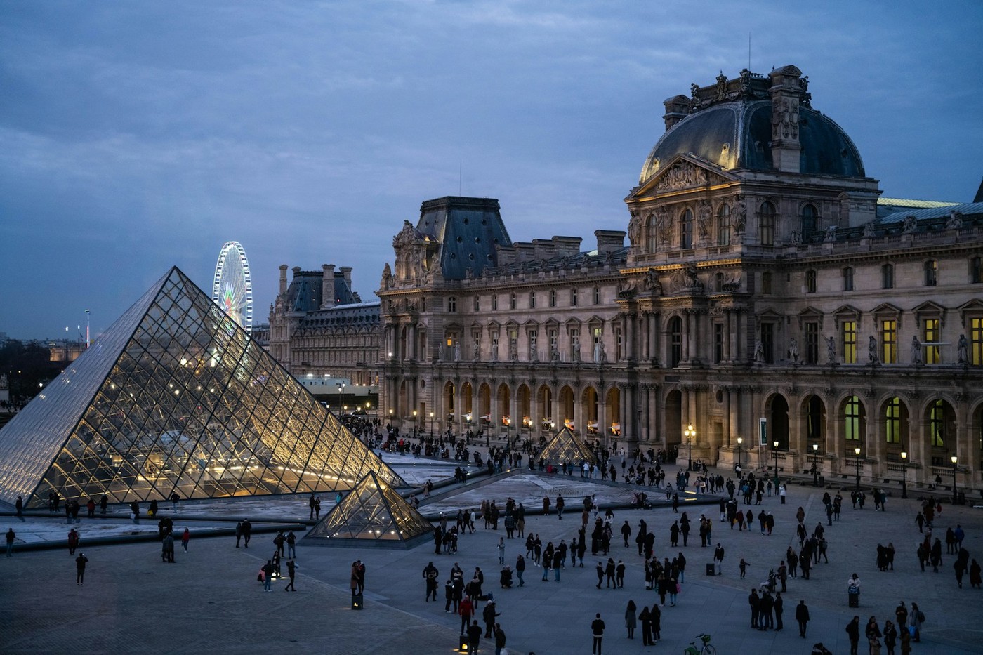 Foule de visiteurs et pyramide de verre dans la cour Napoléon du musée du Louvre